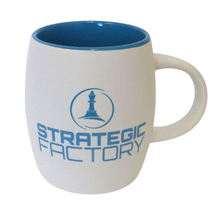 A white coffee mug with a blue Strategic Factory chess piece logo and blue text reading 'STRATEGIC FACTORY'